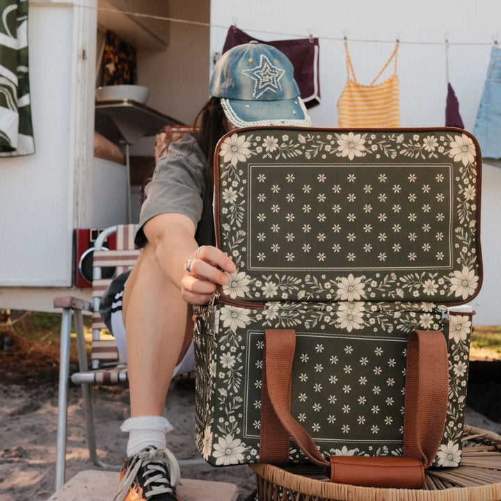SomerSide Eden insulated cooler bag being opened outside beside a caravan, showing the insulated top compartment