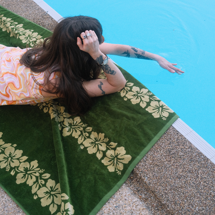 SomerSide Paradiso olive and cream hibiscus cotton towel in use beside a swimming pool